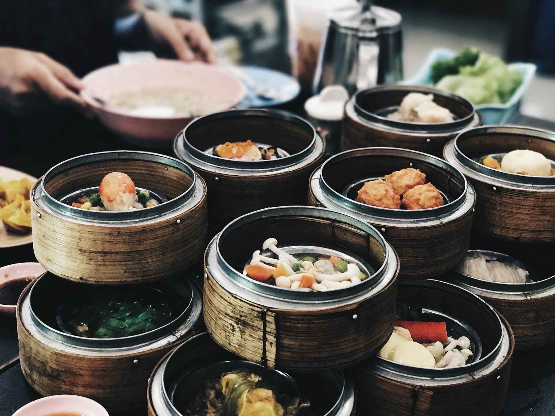 Several bamboo steamers of dim sum arranged on a shared breakfast table