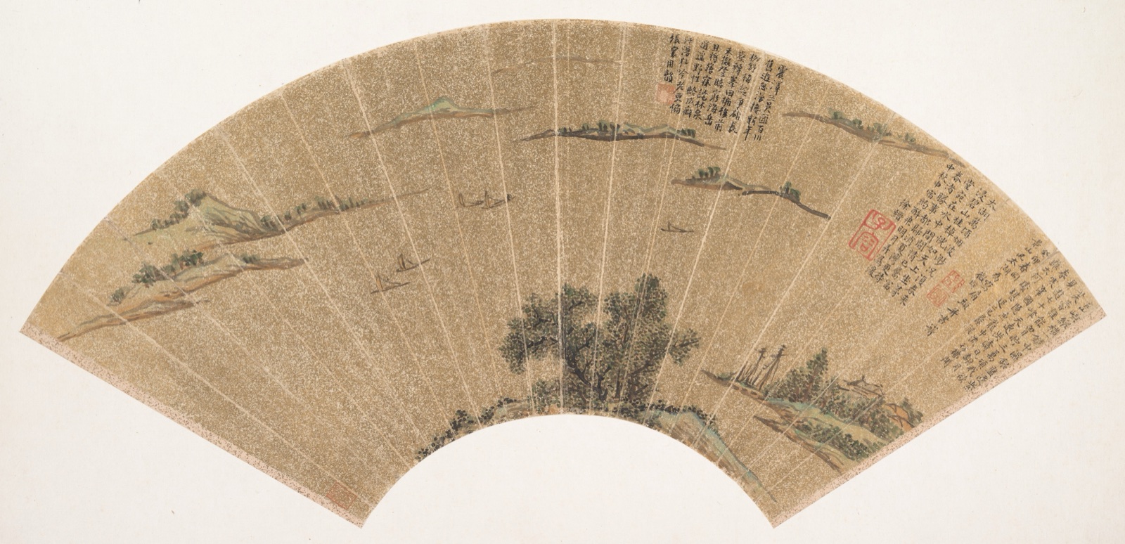 Fan-shaped painting of small boats and islands on gold-flecked paper, with trees below and inscriptions to the right.