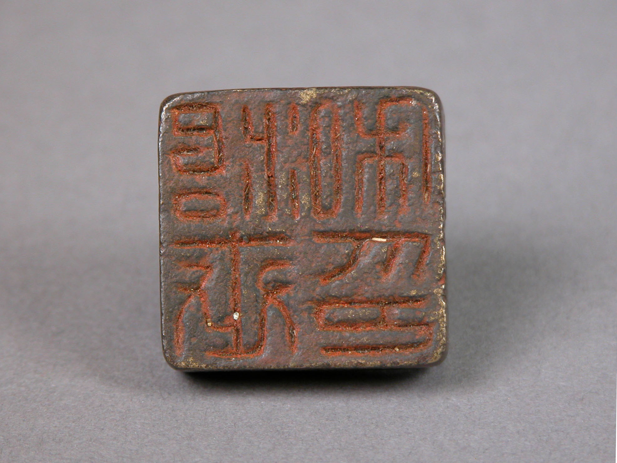 A small bronze private seal preserves a name through its carved impression.