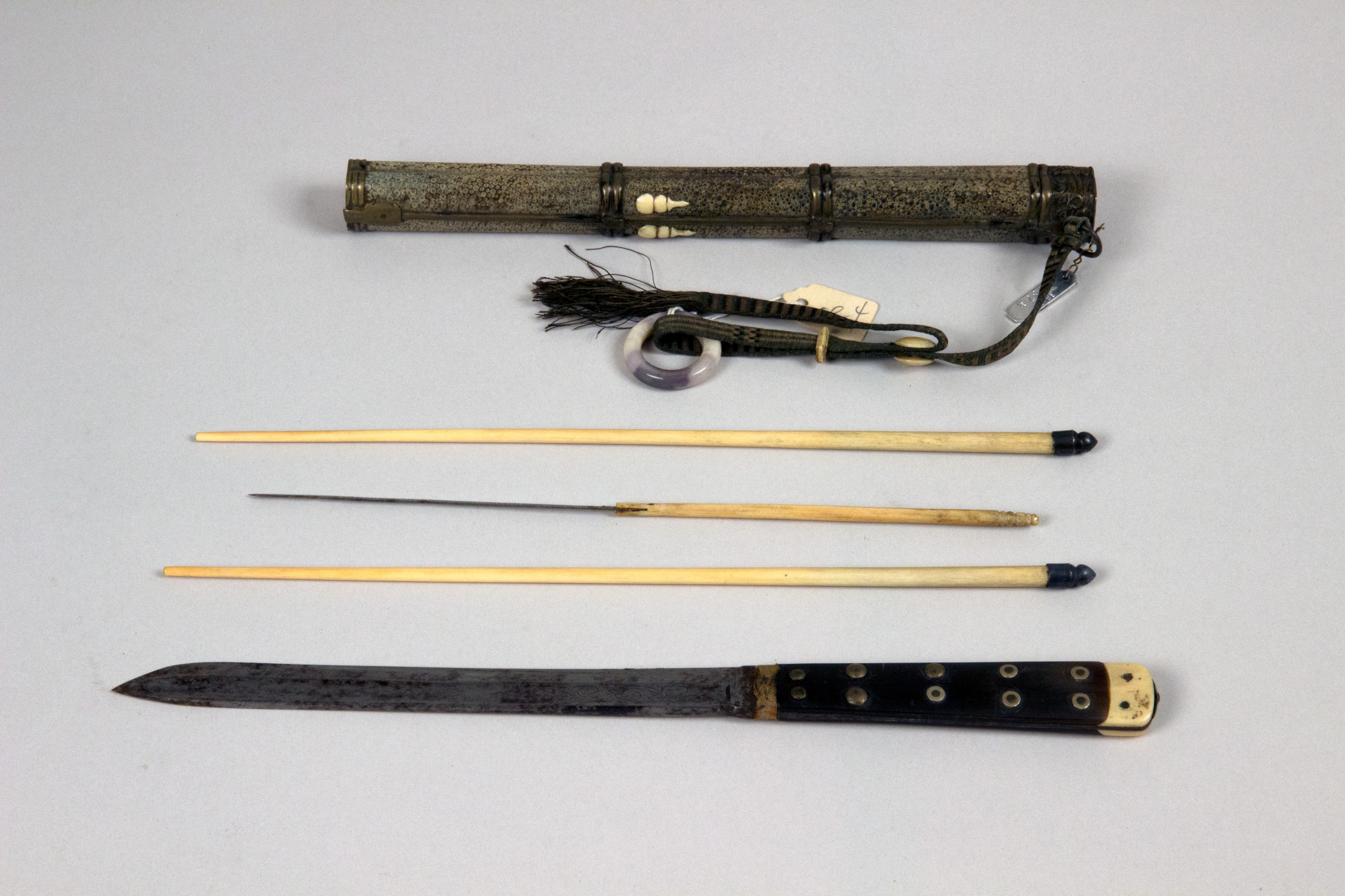 A Chinese travel dining set gathers chopsticks, a knife and small implements inside a sheath.