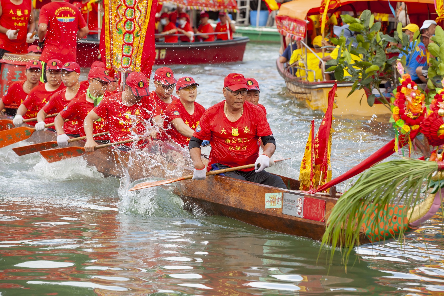 Dragon boats tow sacred sampans through the waterways of Tai O during a local water parade.
