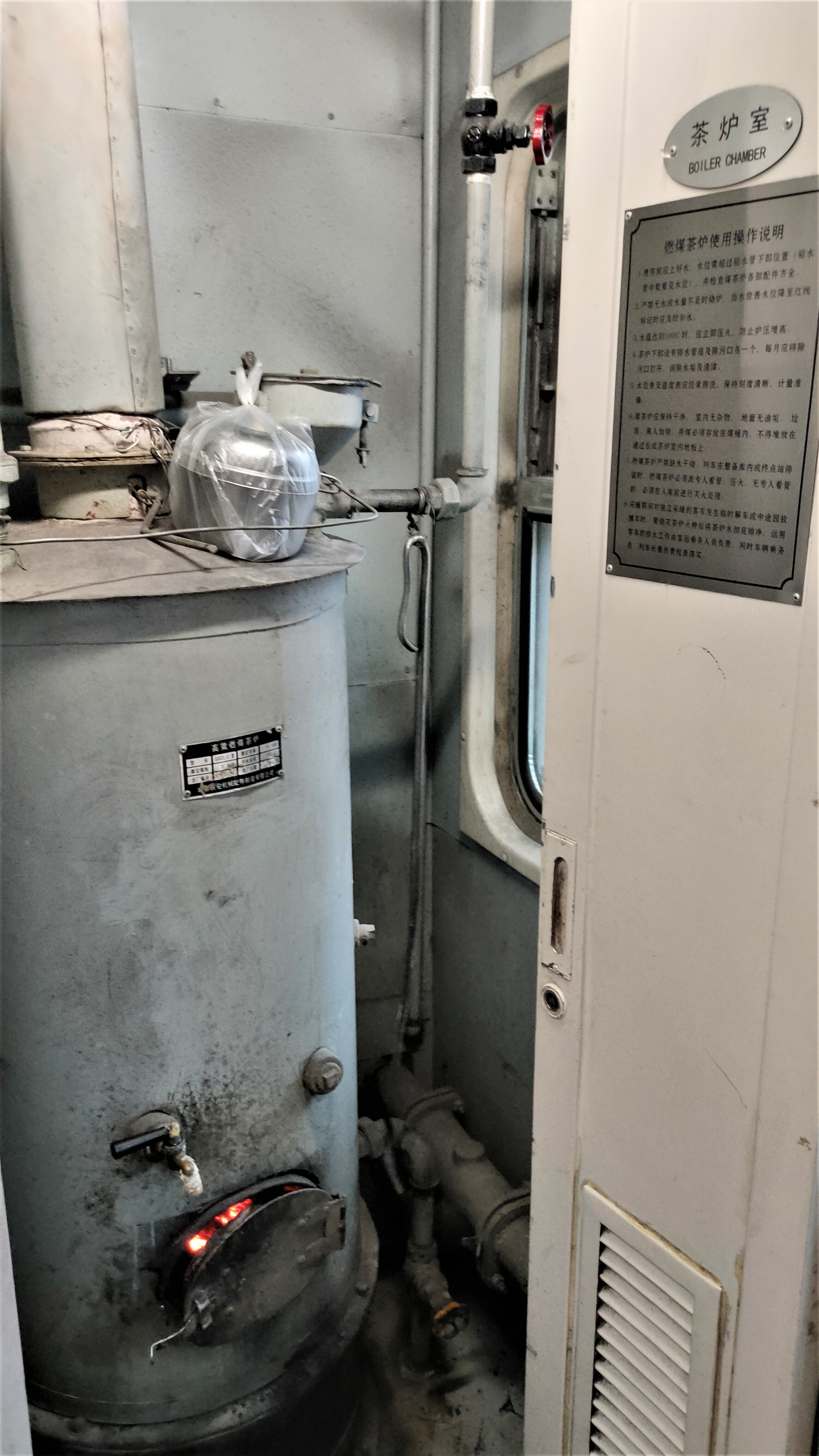 Metal hot-water boiler built into a conventional Chinese railway carriage.