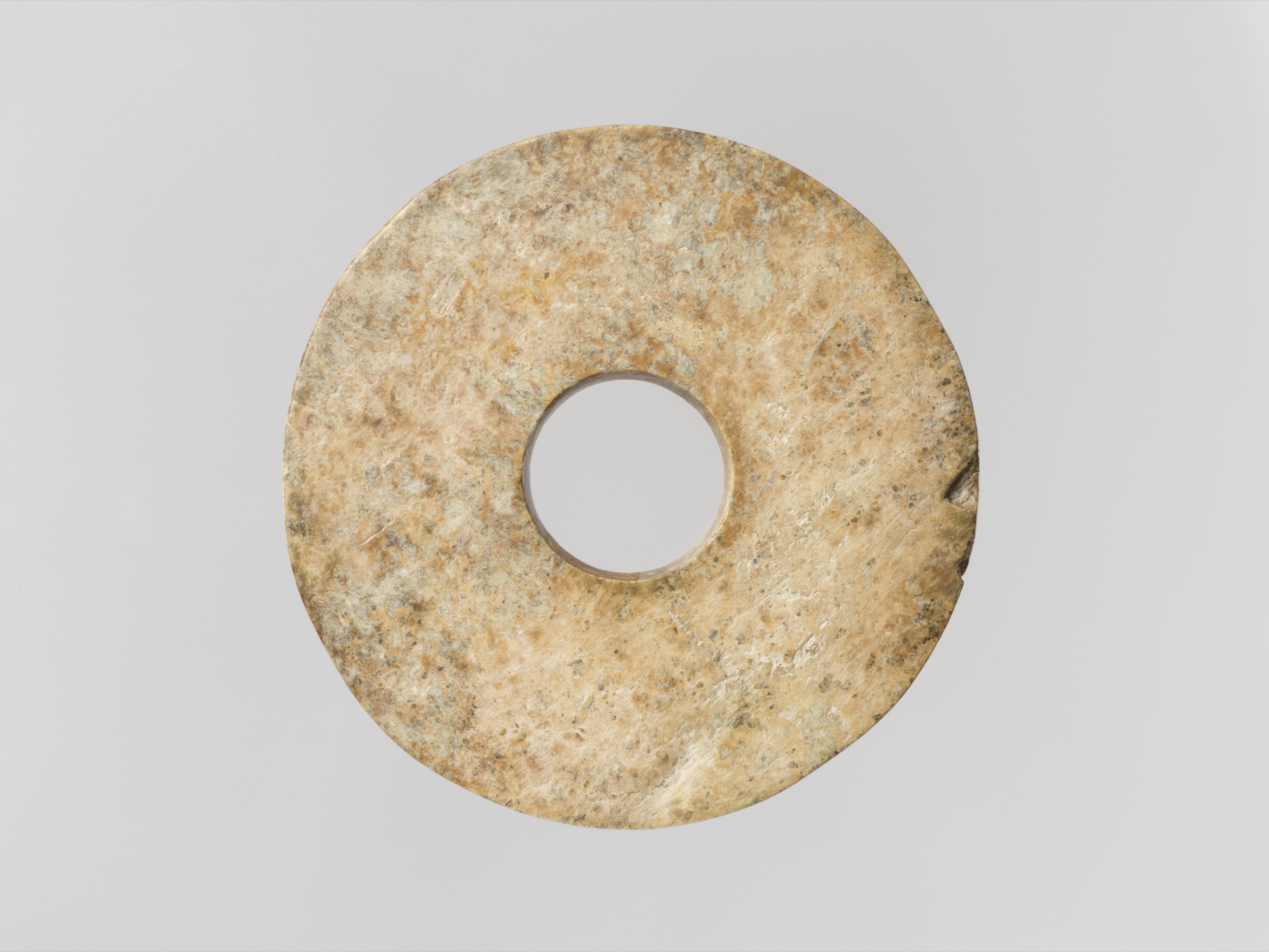 A carefully worked Neolithic bi disk demonstrates the labor invested in early jade objects.