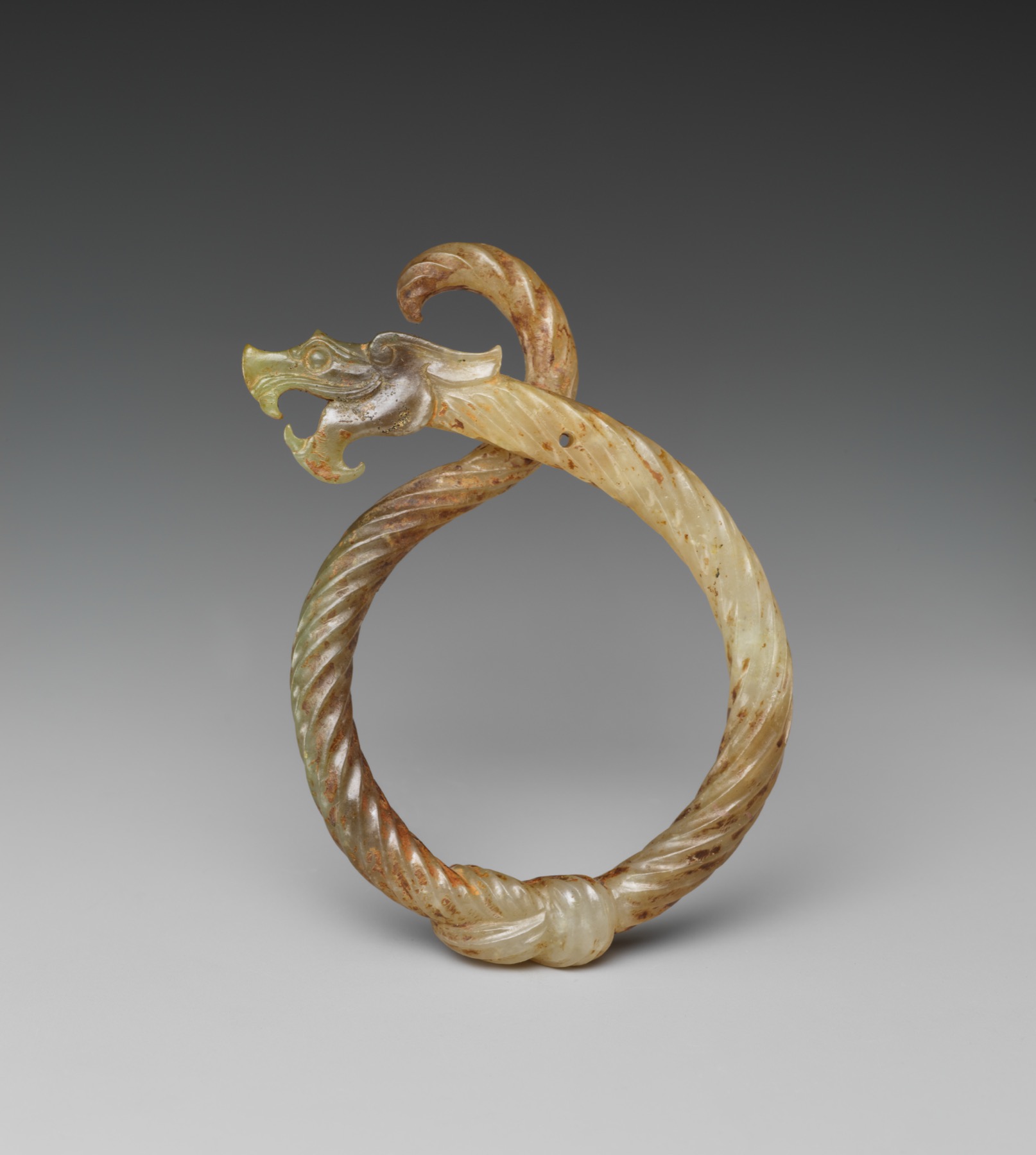 Interlocking dragon forms transform a jade ring into a compact display of carving and symbolism.
