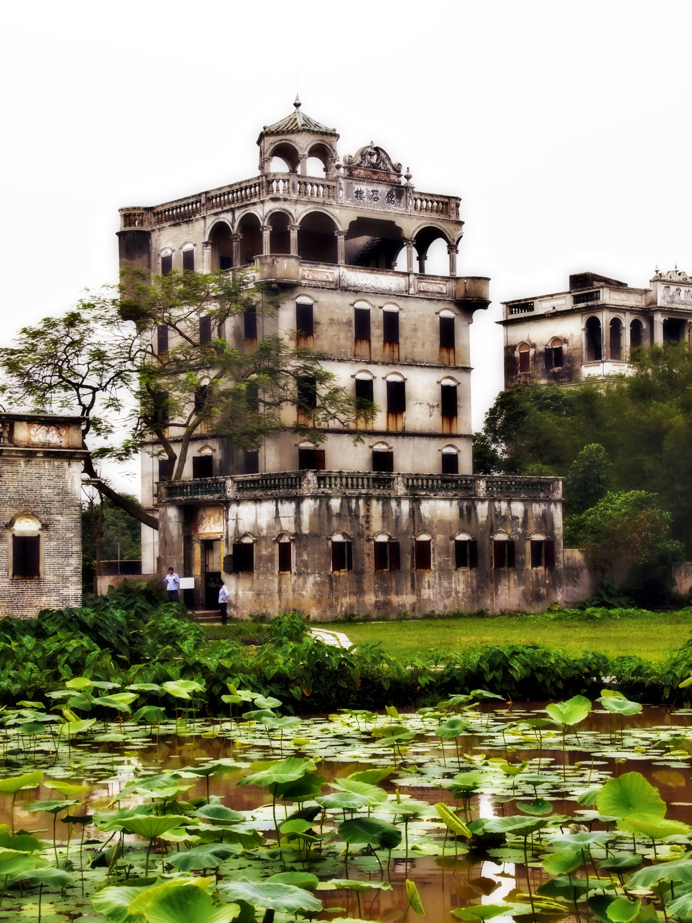 Mingshi Lou places an ornate upper pavilion above a fortified concrete body.
