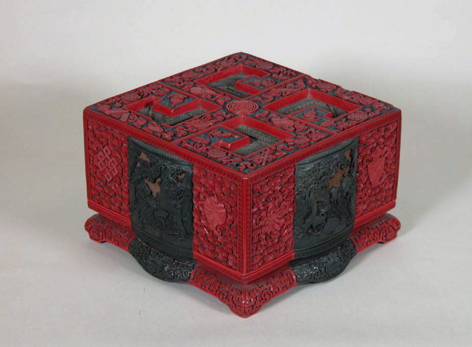 Qing carved lacquer box with red landscape panels and auspicious emblems.