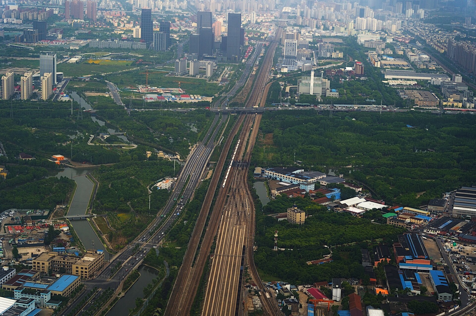 An aerial view places a Hexie high-speed train within Shanghai’s expansive rail landscape.
