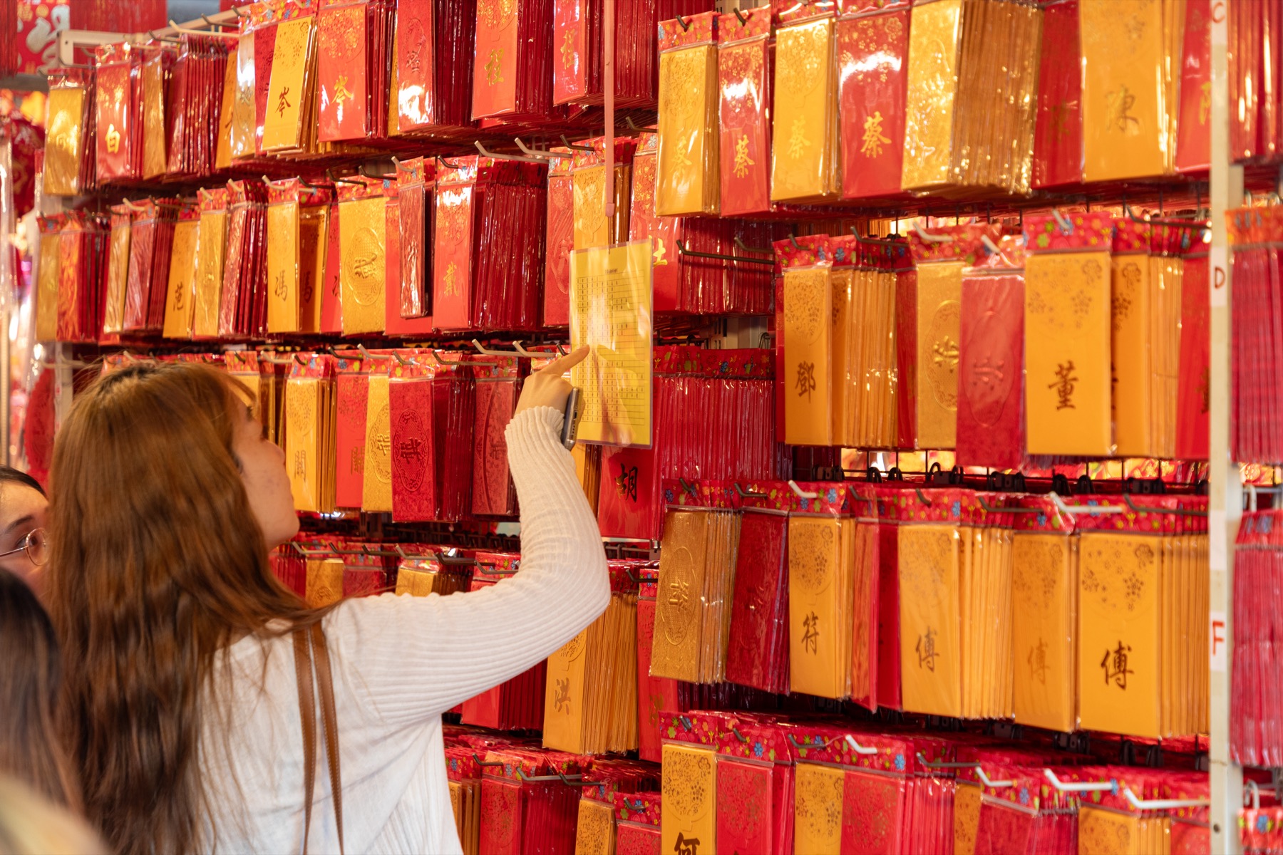 Young shoppers choose red envelopes in Singapore ahead of Lunar New Year.