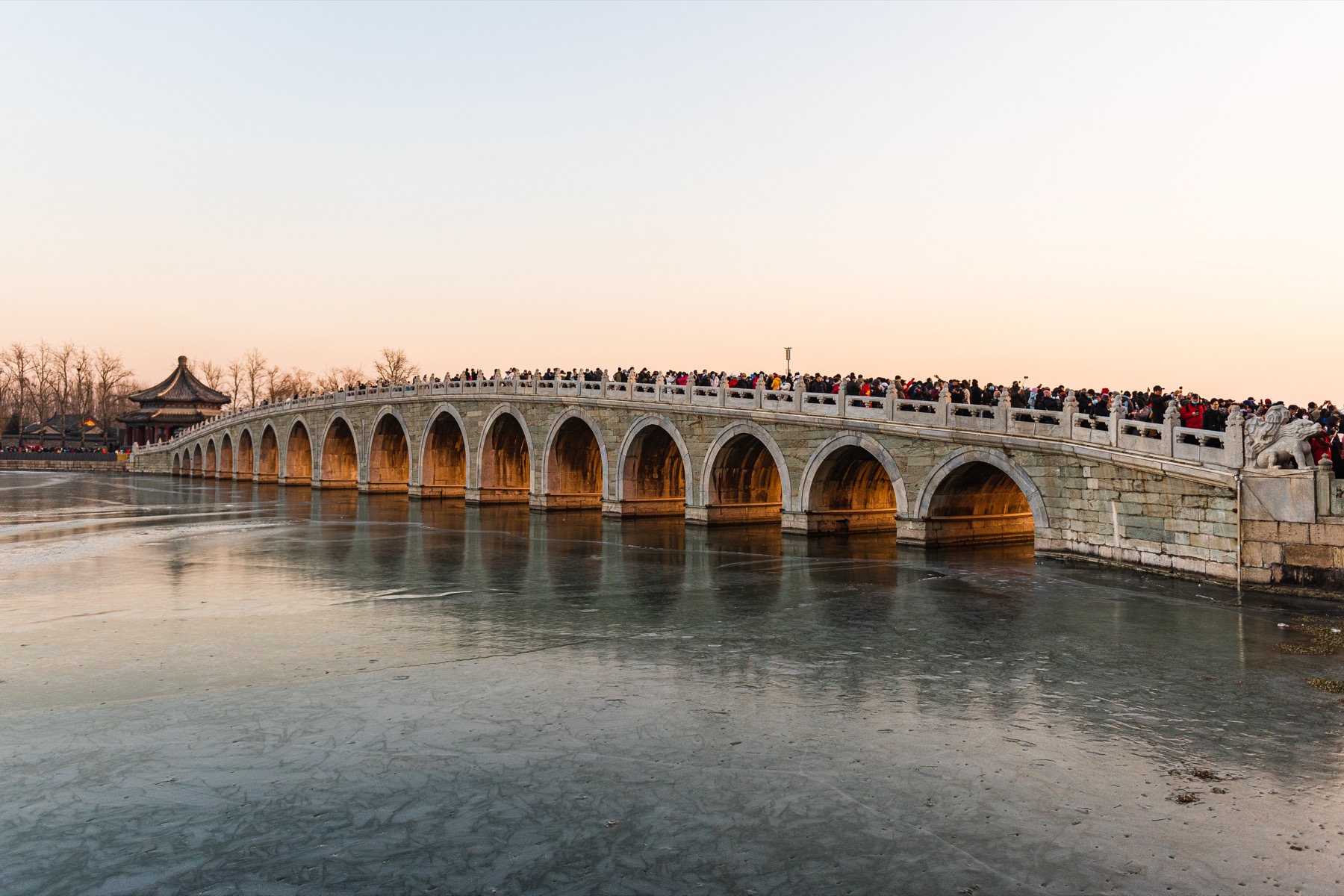 Low winter-solstice sunlight passes through the arches of the Summer Palace’s Seventeen-Arch Bridge.