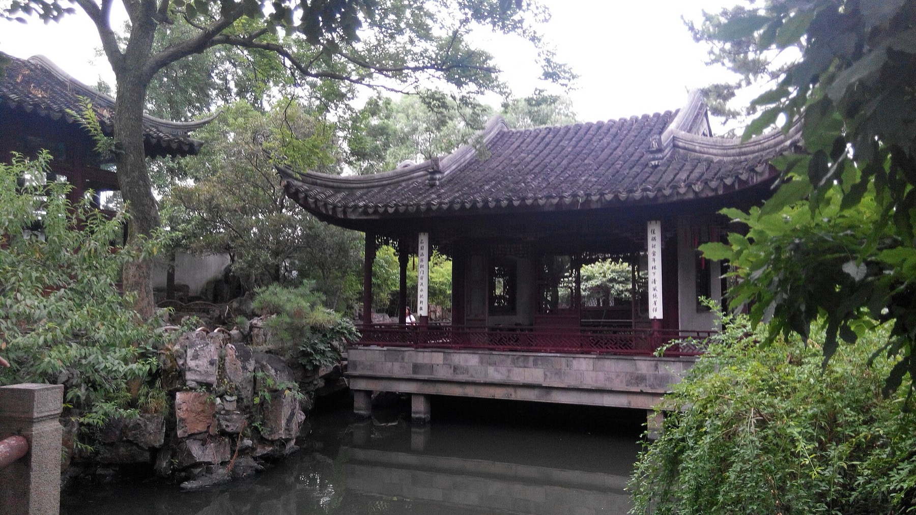 A pavilion frames water, stone and planting in a classical Suzhou garden.