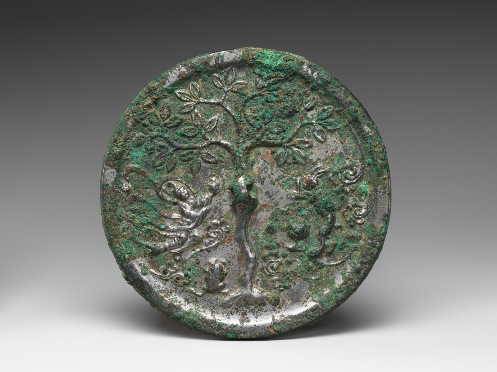 Decorated back of a bronze mirror with lunar figures.